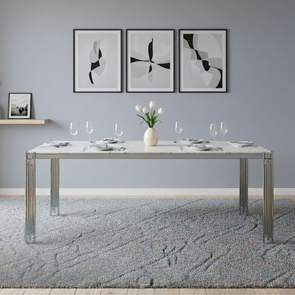 Dining table with marble top and modern decor in a room with abstract art on the wall.