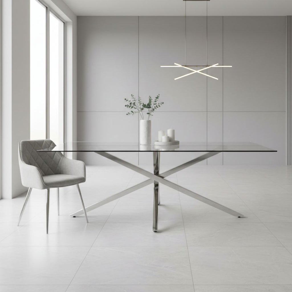 Modern dining room with a glass table and gray chairs in a minimalistic setting.