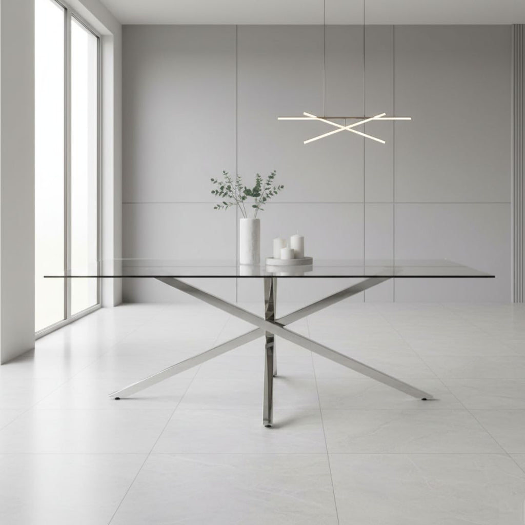 Modern glass dining table with metal legs in a minimalistic room.